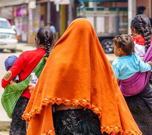 Cropped image of a family, facing away from the camera.