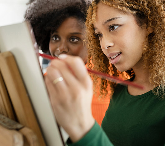 two girls writing on paper